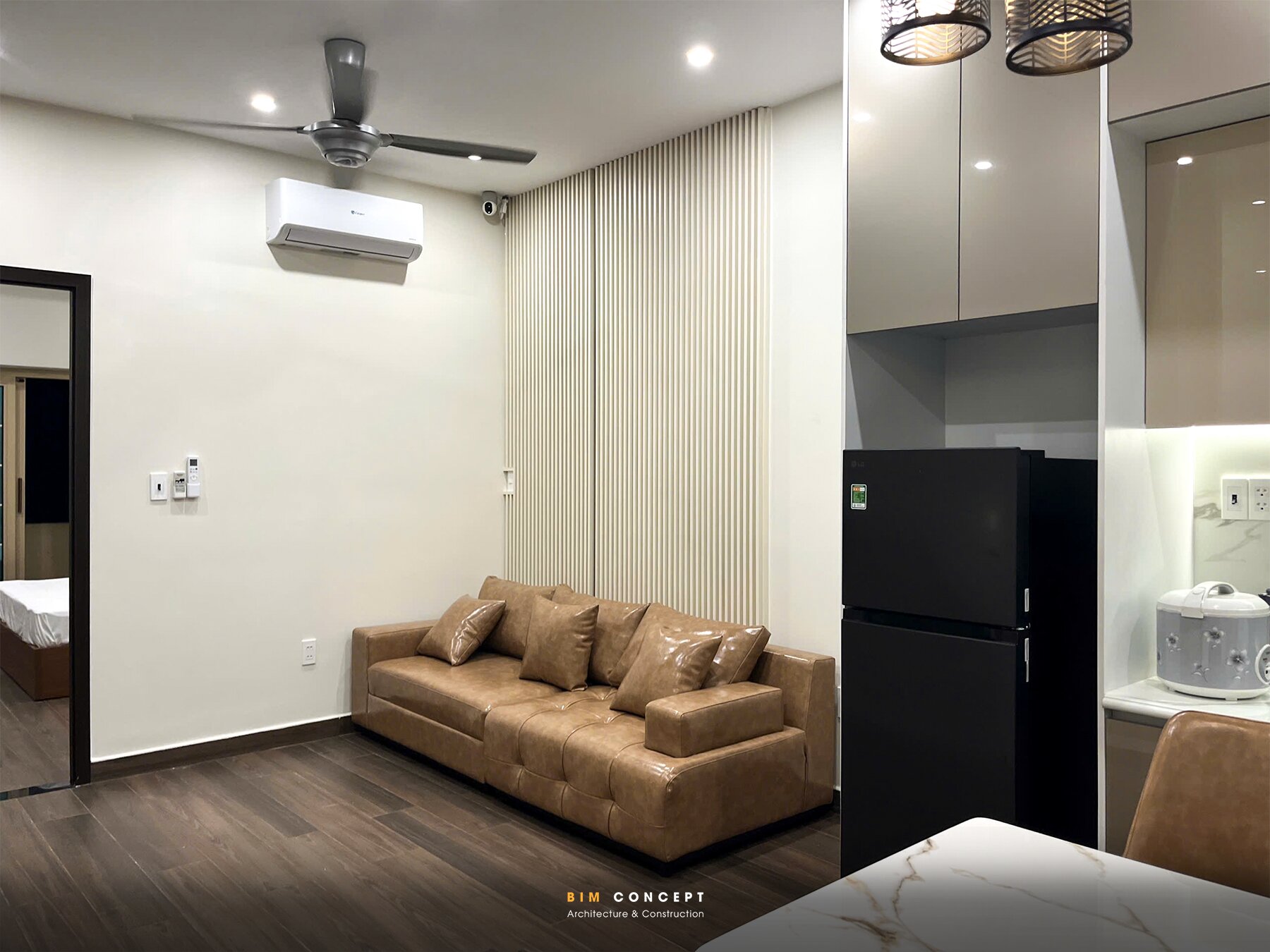 Phòng sinh hoạt chung, sofa da nâu, tủ bếp nhỏ gọn.