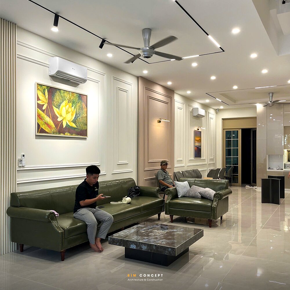 Thi công phòng khách tân cổ điển với bộ sofa da màu xanh.